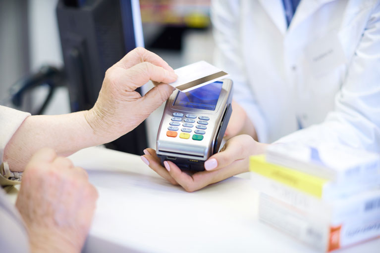 Older woman paying at a pharmacy with a credit card